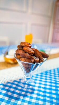 Bowl of Medjool dates ready for iftar with warm checkered cloth in soft natural light