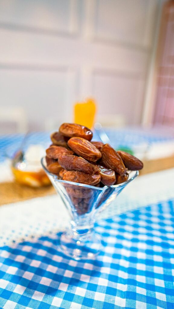 Bowl of Medjool dates ready for iftar with warm checkered cloth in soft natural light
